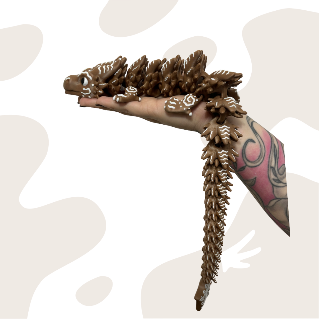 Piernikowy Smok Flexi o długości 46 cm, brązowy, z ruchomymi segmentami, trzymany w dłoni. Idealny jako ozdoba świąteczna lub zabawka interaktywna.